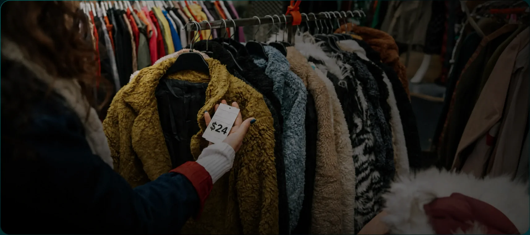 Shopper checking a price tag on a rack of coats