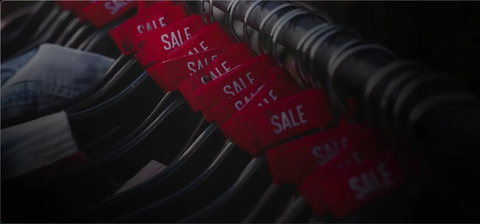 Rack of clothing with red sale tags